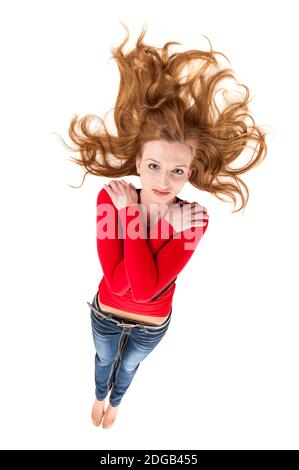 Vista completa di una giovane donna sdraiata su bianco con capelli biondi allungati e braccia incrociate di fronte il suo petto in una vista rialzata guardando seri Foto Stock