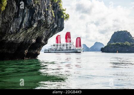 Una barca naviga sulla Baia di ha Long, un sito patrimonio dell'umanità dell'UNESCO. Ogni giorno molte navi da crociera navigano nel complesso roccioso pieno di turisti Foto Stock