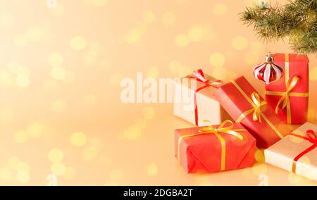 Regali favolosi in belle scatole multicolore con nastri d'oro sotto un albero di Natale decorato con giocattoli in vetro. Vacanze. Anno nuovo e Natale. P. Foto Stock