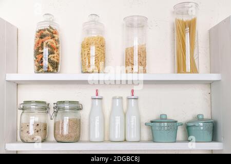 Vari generi alimentari non cotti in vasetti di vetro sullo scaffale in cucina Foto Stock