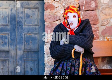 Mascarita - personaggio mascherato, seduto su una panchina in attesa dell'arrivo dei diavoli. Carnevale di Luzon. Due personaggi sono i protagonisti del Luzon Carn Foto Stock