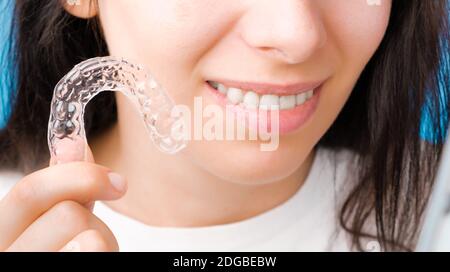 un' donna mette su un invisibile silicone denti allineatore. dentale  bretelle per denti correzione 27585141 Stock Photo su Vecteezy