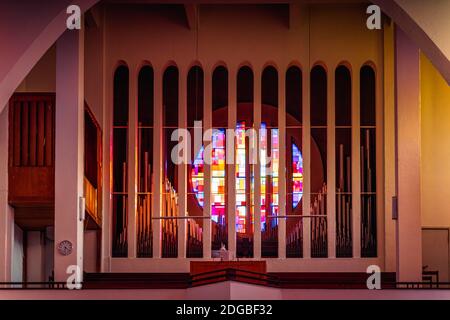 Szczecin, Polonia, giugno 2019 organi di Tall pipe nella Chiesa Cattolica Romana, parrocchia della Sacra Famiglia con vetro rotondo multicolore sullo sfondo Foto Stock
