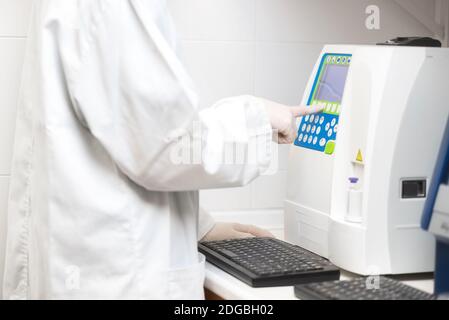 Test medico scientifico con analisi ematologiche automatizzate. Foto Stock