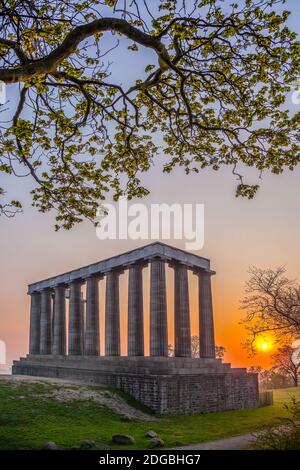 Vista del Monumento Nazionale della Scozia contro il tramonto sulla collina di Calton a Edimburgo, Scozia Foto Stock