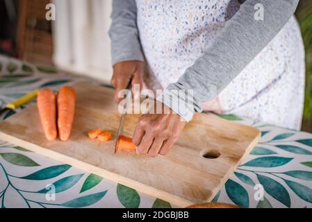 donna nera con gli occhiali insegna online con il suo telefono cellulare lezioni di cucina da casa Foto Stock