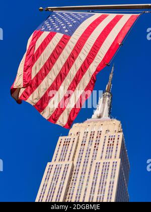 L'iconico Empire state Building è visto con una bandiera americana sulla Fifth Avenue, New York City, USA Foto Stock