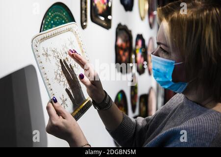 Mosca, Russia. 8 Dic 2020. Un lavoratore controlla la qualità di un vassoio decorato a mano presso la fabbrica di pittura decorativa Zhostovo, nella regione di Mosca, Russia, l'8 dicembre 2020. Zhostovo è un centro d'arte popolare russo famoso per i suoi vassoi dipinti decorati con brillanti grappoli di fiori. Credit: Maxim Chernavsky/Xinhua/Alamy Live News Foto Stock