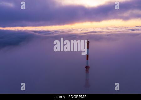 Torre delle comunicazioni che si erge attraverso un tappeto di nuvole all'alba, Salisburgo, Austria Foto Stock