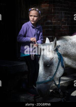 Ragazza che intreccia la frangia di un cavallo Foto Stock