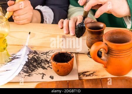 Un inkwell con una penna bianca trapanata tradizionali accessori scritti a mano stare su un tavolo di legno Foto Stock