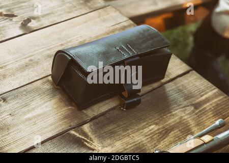 Tradizionale borsa vintage in pelle, foto vintage sul tavolo Foto Stock