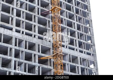 Alto edificio per uffici in cemento da costruzione vicino alla gru di ferro Foto Stock