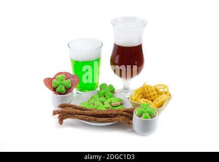 Spuntino di carne due bicchieri di birra verde ambra scuro con trifoglio. Il giorno di San Patrizio Foto Stock