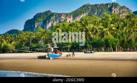 Barca tailandese alla spiaggia con Palmtrees sullo sfondo Foto Stock