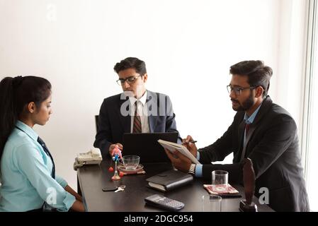 Intervista aziendale di una giovane ed energica candidata femminile in ufficio indiano presa da intervistatore indiano maschio. Azienda indiana. Foto Stock
