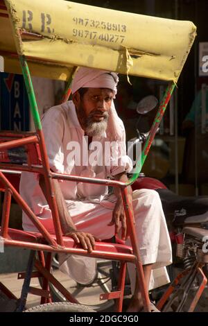 Autista indiano di risciò in attesa di affari, mercato Chandi Chowk, Old Delhi, India Foto Stock
