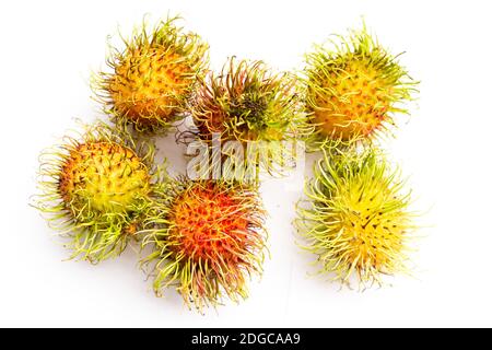 Set di rambutan freschi di frutta asiatica con baffi sdraiati uno sfondo bianco Foto Stock