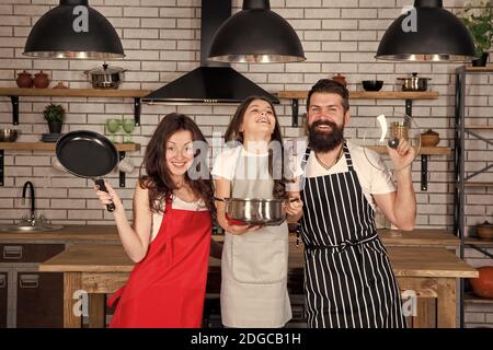 È il momento di mangiare bene. Assistenza e supporto reciproci. Cucina familiare accogliente. Cucina sana a casa. Chef bambino con i genitori. Madre e padre insegnando a figlia come cucinare. Felice giorno di famiglia. Foto Stock