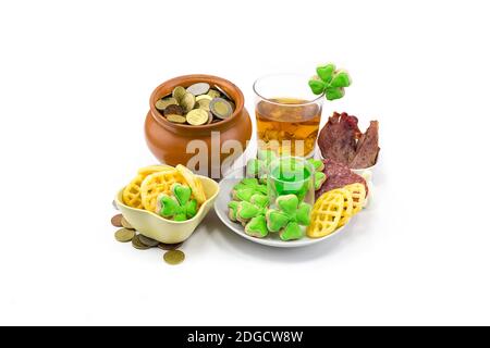 Vasetto di estrazione del ghiaccio in vetro di Scotch con monete d'oro e snack a trifoglio con carne e biscotti. S Foto Stock