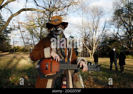 New York City, Stati Uniti. 8 dicembre 2020. Una donna che indossa una maschera e un vestito d'epoca propone una foto per il 40° anniversario della morte di John Lennon, a Strawberry Fields, in Central Park, l'8 dicembre 2020. Ogni anno la gente si riunisce a Central Park e vicino al Dakota, la residenza delle stelle, per onorare la leggenda dei Beatles in New York Credit: Sipa USA/Alamy Live News Foto Stock