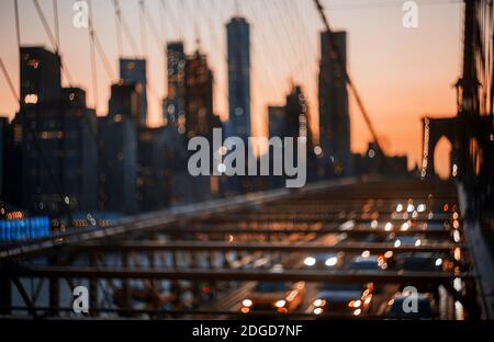 New York City Brooklyn Bridge ha difocuso le luci notturne astratte della città sfondo Foto Stock