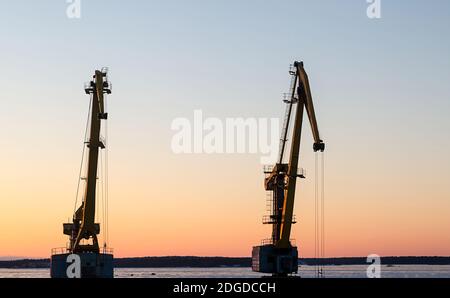 Gru porto tramonto sfondo. Background industriale potenti macchine per il trasporto di oggetti, merci Foto Stock