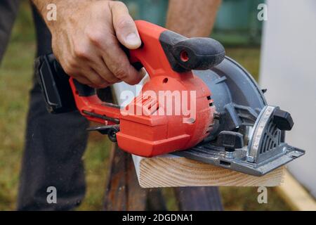 Lavoratore utilizzando una mano sega circolare per tagliare un tetto-tile  Foto stock - Alamy