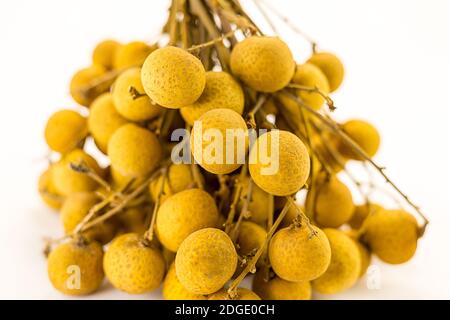 Giallo frutta succosa bacche frutta asiatica longan su un ramo primo piano su sfondo bianco Foto Stock