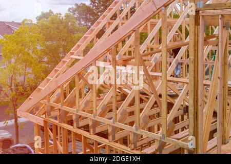 Panorama di condominio con costruzione in costruzione casa di legno con strutture in legno, capriate, travetto, trave in primo piano Foto Stock