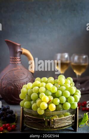 Uva e vino in una brocca e bicchieri Foto Stock