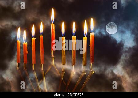 Menorah con candele per hannukah festa celebrazione con luna piena cielo di notte sfondo Foto Stock