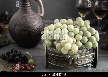 Uva e vino in una brocca e bicchieri Foto Stock