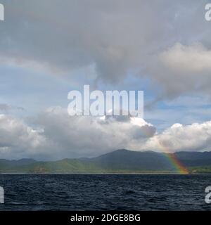 L'arcobaleno dall'oceano e l'isola sullo sfondo Foto Stock