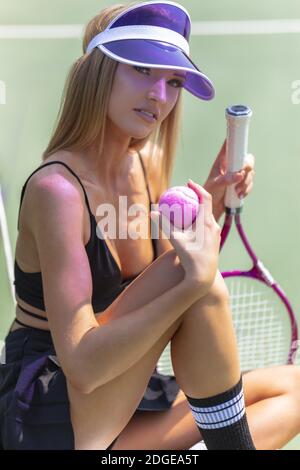 Un bel modello Blonde gioca a tennis su un caldo Summers Giorno Foto Stock