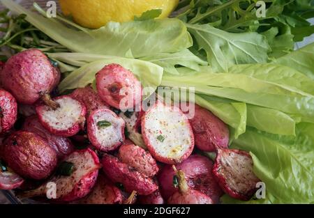 Rafano cotti al forno con le cipolle verdi e insalata. Foto Stock