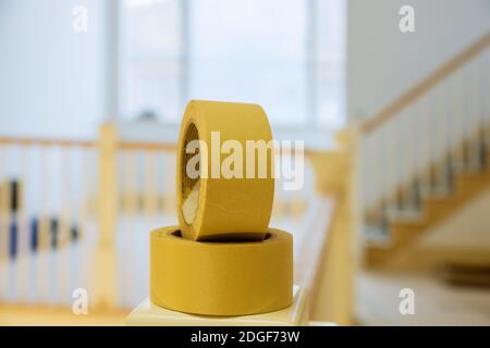 Rotolo di nastro verniciante giallo su nastro adesivo verniciato parete Foto Stock