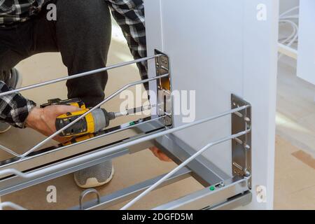 Man mano assemblaggio di mobili spazzatura in cucina Foto Stock