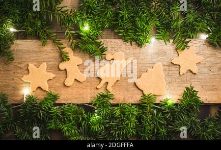 Biscotti di pan di zenzero sul tavolo di legno prima di Natale. Tradizioni di Natale. Decorazioni natalizie. Foto Stock