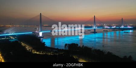 Una vista aerea delle lampioni lungo il Fifth Yangtze River Bridge è stata attivata e disattivata a sua volta per testare il sistema di illuminazione, che sarà completamente finito Foto Stock