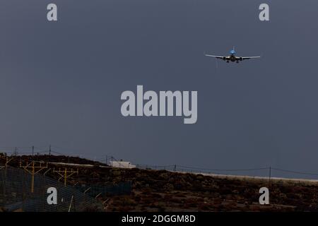 Aereo di linea che entra a terra sotto le nuvole di pioggia pesanti. Foto Stock