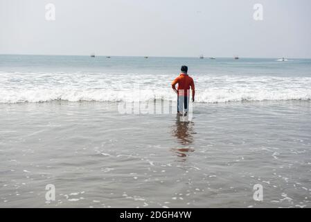 Goa, India- 10 Novembre 2020, l'uomo si trova in mare acqua guardare oltre l'orizzonte a Baga Beach Goa Foto Stock