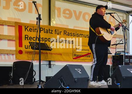 Braunschweig, Germania, 05 dicembre 2020: Cantante con chitarra acustica in una manifestazione contro il razzismo e il populismo di destra Foto Stock