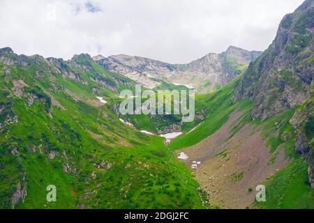 Vista aerea di una valle di montagna con prati alpini e. flussi Foto Stock