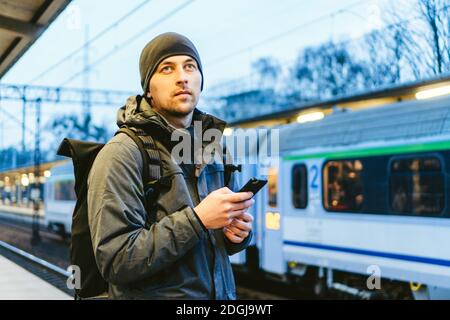 Sopot Stazione ferroviaria veloce Urbana. Giovane uomo in piedi e in attesa treno su piattaforma. viaggi turistici in treno. Ritratto di Caucas Foto Stock