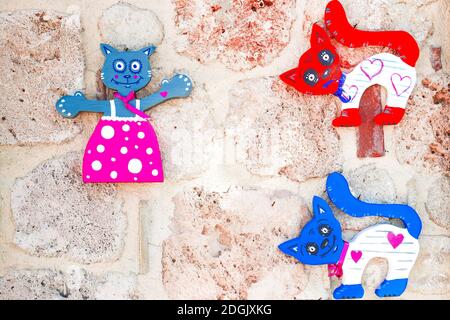 Funny figure di decorazione di gatto di colore di legno su sfondo di pietra. Foto Stock