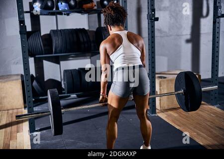 Donna dai capelli scuri sportiva che fa l'allenamento di forza Foto Stock