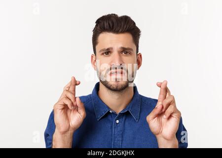 Primo piano ritratto di deluso sottolineato ragazzo bearded in camicia su sfondo bianco. Foto Stock