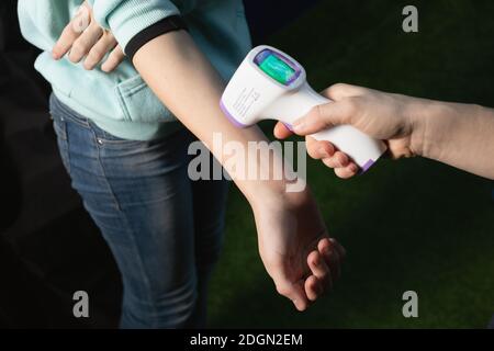 Misurazione della temperatura a mano del bambino con un dispositivo di misurazione digitale della temperatura senza contatto. Foto Stock