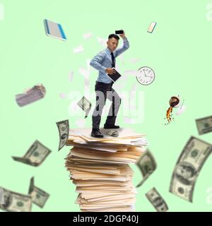Lavoratore d'ufficio, uomo d'affari, sportivo combattendo con scadenze in piedi sul mazzo di documenti con denaro volante. Business moderno e finanza, sport, tempo, arte creativa, design contemporaneo. Foto Stock